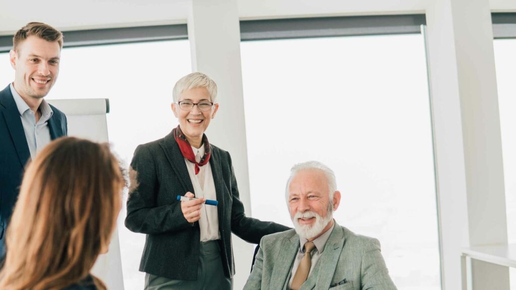 team multigenerazionale in riunione aziendale: un leader facilita la collaborazione tra generazioni diverse